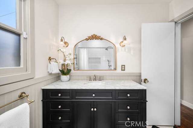 full bath featuring curtained shower, vanity, and wood finished floors