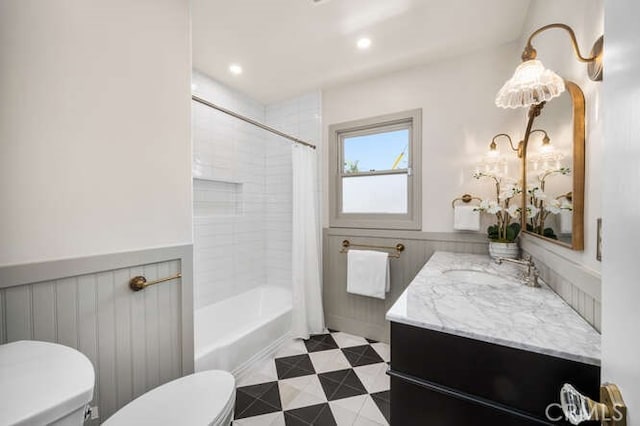 full bath featuring toilet, a wainscoted wall, shower / bathtub combination with curtain, and vanity