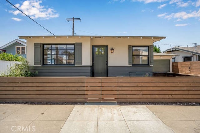 view of front of house with a fenced front yard and stucco siding