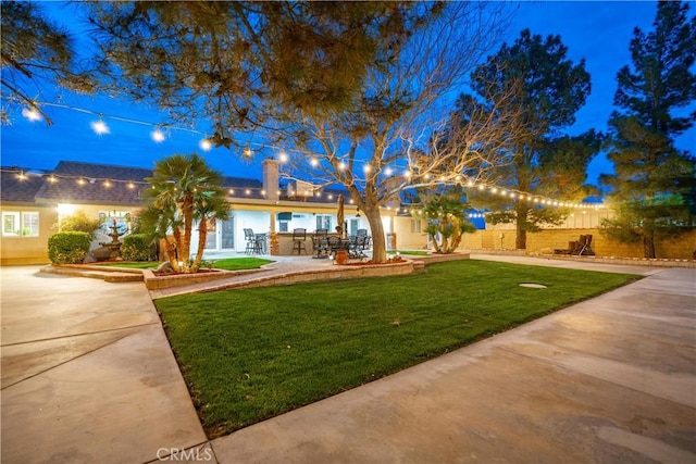 view of front of home featuring a patio, a front lawn, and fence