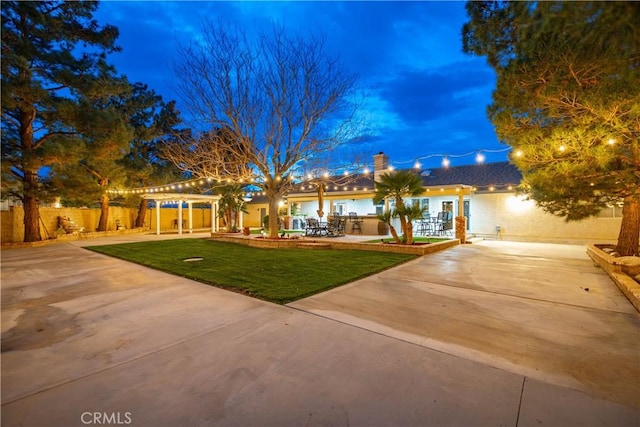 view of front of property with fence, a pergola, a front lawn, a chimney, and a patio area