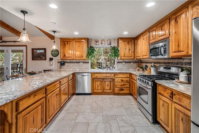 kitchen with stainless steel appliances, brown cabinetry, and plenty of natural light