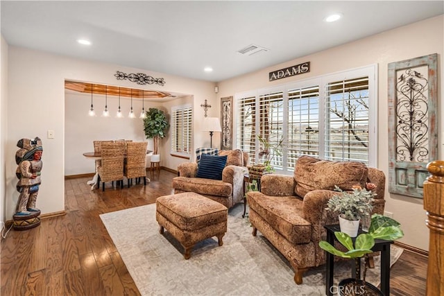 living area with baseboards, visible vents, wood finished floors, and recessed lighting