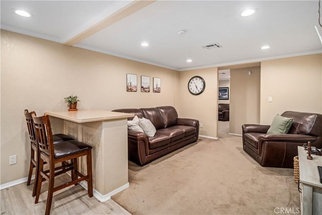 living area with recessed lighting, visible vents, crown molding, and baseboards