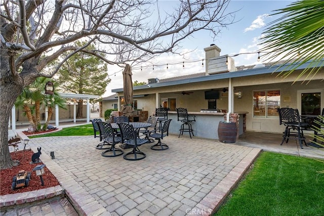 view of patio with outdoor dining area, ceiling fan, and outdoor dry bar