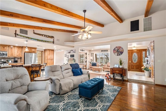 living area featuring beam ceiling, visible vents, dark wood finished floors, and baseboards