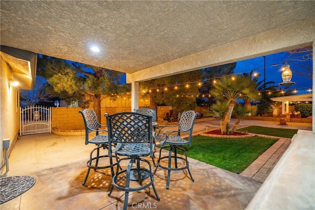 view of patio featuring outdoor dining space, fence, and a gate