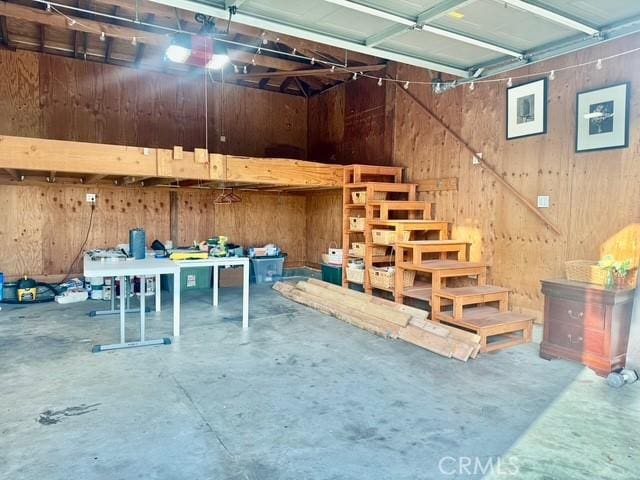 basement featuring a garage and wooden walls