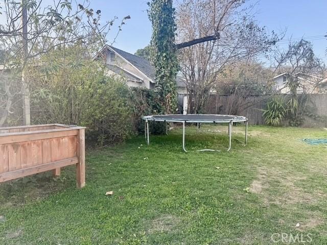 view of yard with a fenced backyard and a trampoline