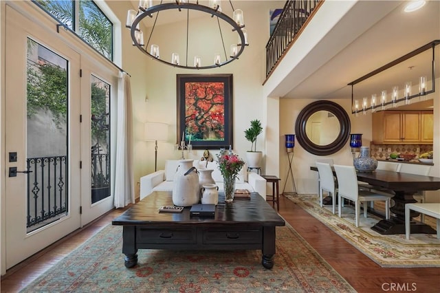 interior space featuring a chandelier, wood finished floors, and a towering ceiling