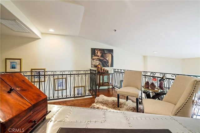 sitting room with lofted ceiling, visible vents, recessed lighting, and wood finished floors