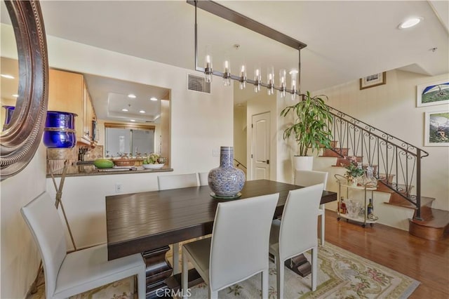 dining space with stairway, visible vents, wood finished floors, and recessed lighting