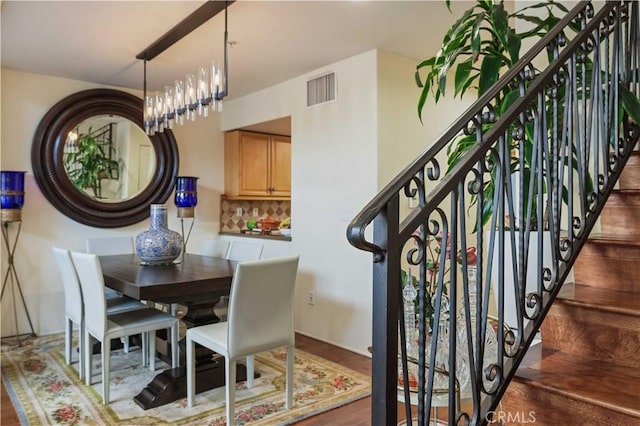 dining room featuring stairs, visible vents, and wood finished floors