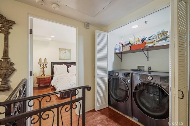 clothes washing area featuring laundry area, dark wood-style flooring, baseboards, and separate washer and dryer