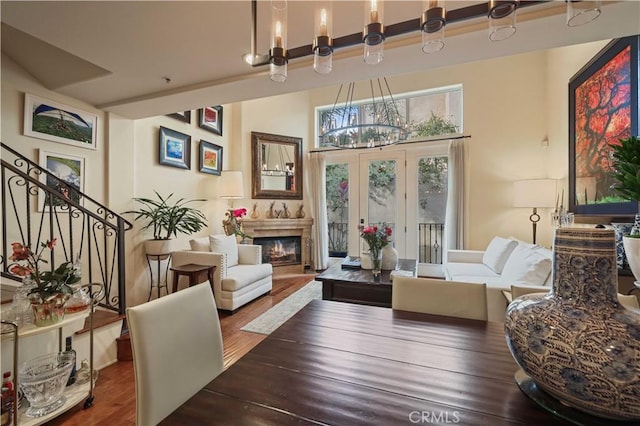 living area featuring a glass covered fireplace, stairway, and wood finished floors