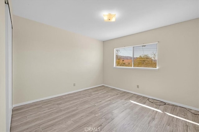 spare room with wood finished floors and baseboards