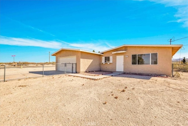 view of front of home with an attached garage, fence, driveway, and stucco siding