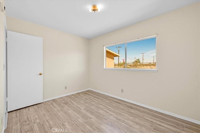 empty room featuring wood finished floors and baseboards