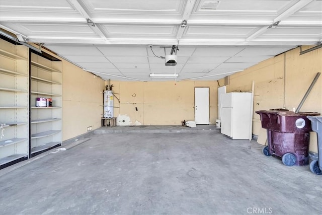 garage featuring strapped water heater, a garage door opener, and freestanding refrigerator