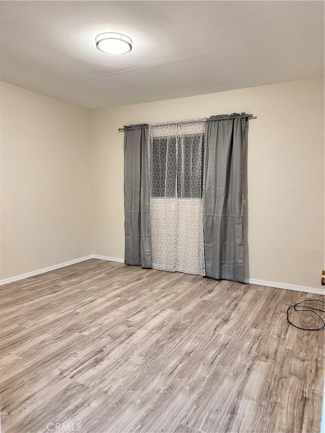 empty room featuring baseboards and wood finished floors