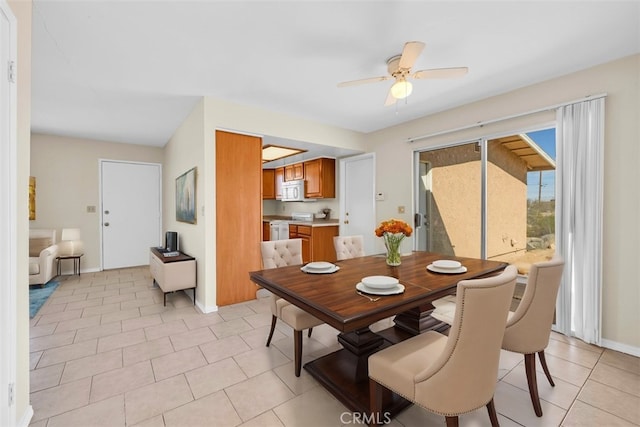 dining space with light tile patterned floors, a ceiling fan, and baseboards