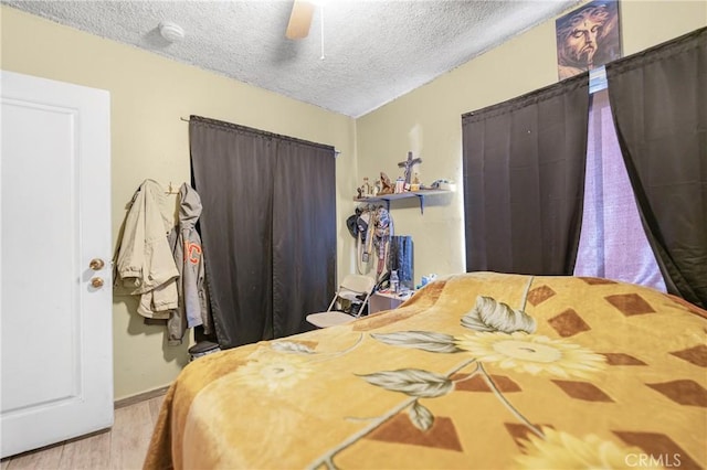 bedroom with a textured ceiling and a ceiling fan