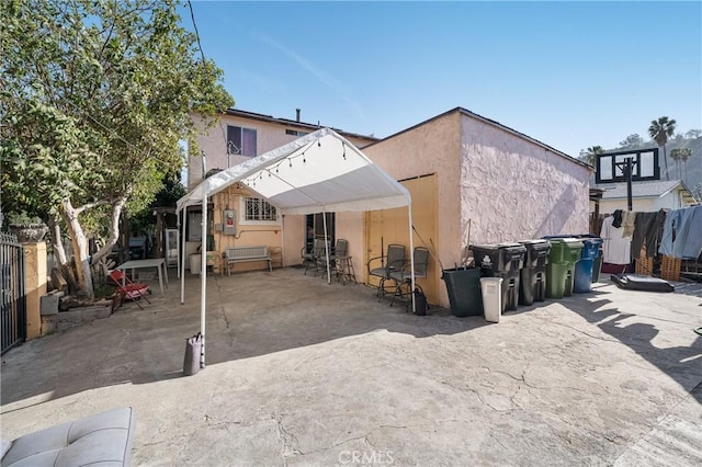 back of house with a patio, fence, and stucco siding