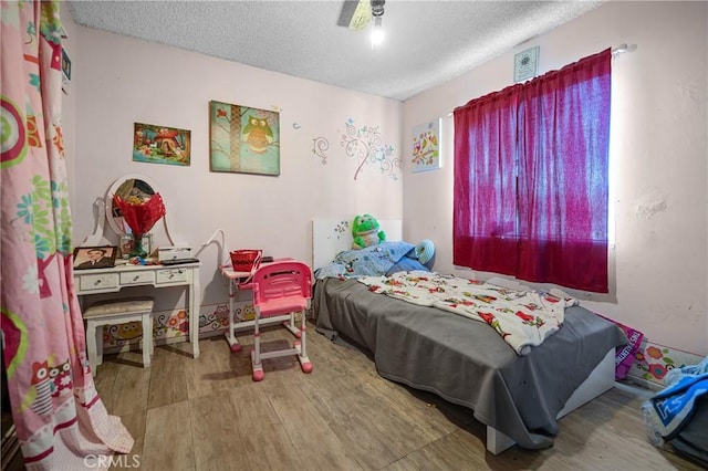 bedroom with a textured ceiling and wood finished floors