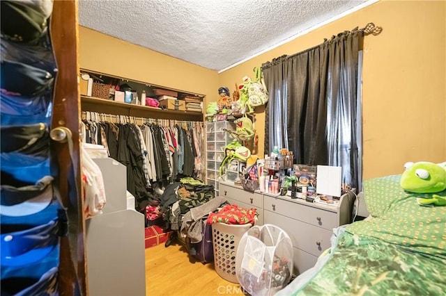 walk in closet with wood finished floors