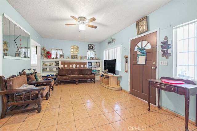 living room with a textured ceiling and ceiling fan