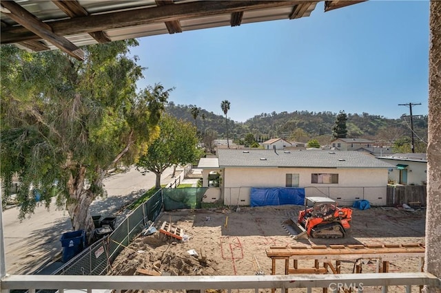 back of house featuring a mountain view and a fenced backyard