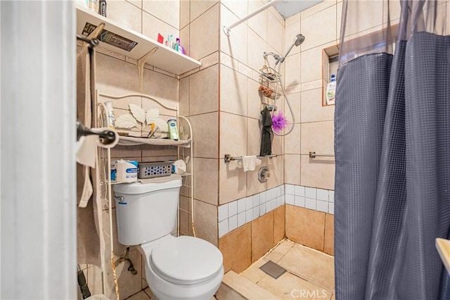 bathroom featuring tiled shower and toilet