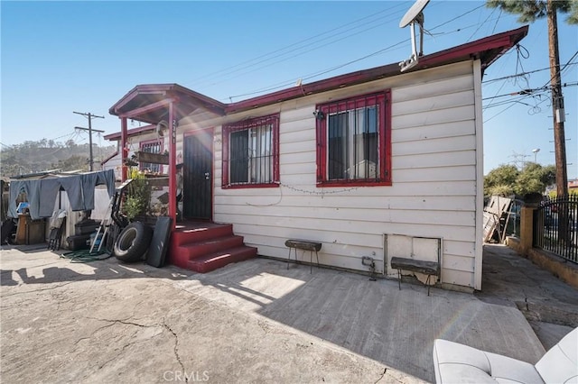 view of property exterior featuring a patio and fence