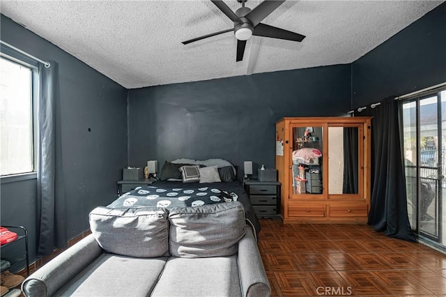 bedroom with vaulted ceiling, a ceiling fan, and a textured ceiling