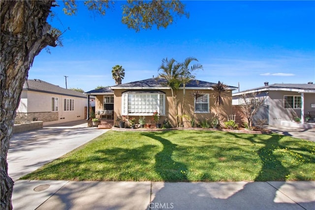 ranch-style home featuring stucco siding, concrete driveway, and a front yard