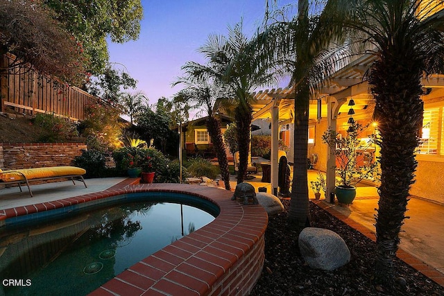 pool at dusk with an outdoor pool, a patio, fence, and a pergola