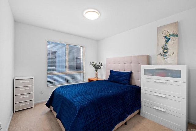 bedroom with baseboards and light colored carpet