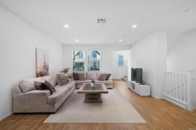 living room featuring recessed lighting, baseboards, visible vents, and light wood finished floors