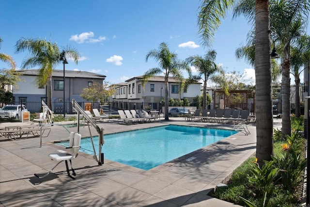 community pool with a patio and fence