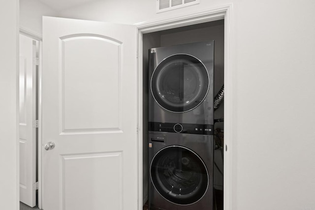 laundry room with stacked washer and dryer, laundry area, and visible vents