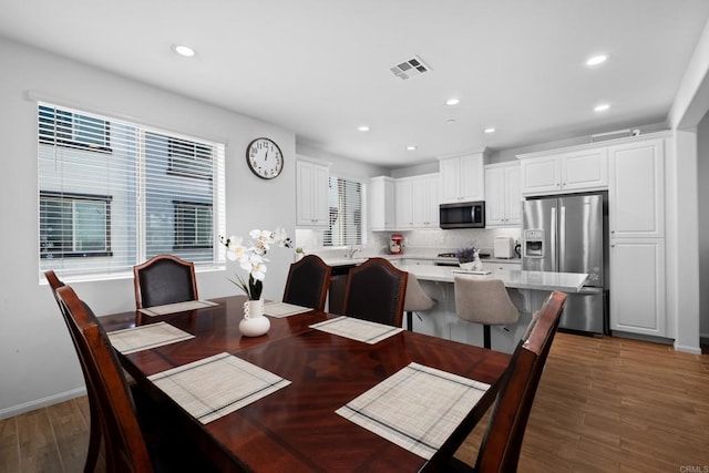 dining room featuring wood finished floors, visible vents, and recessed lighting