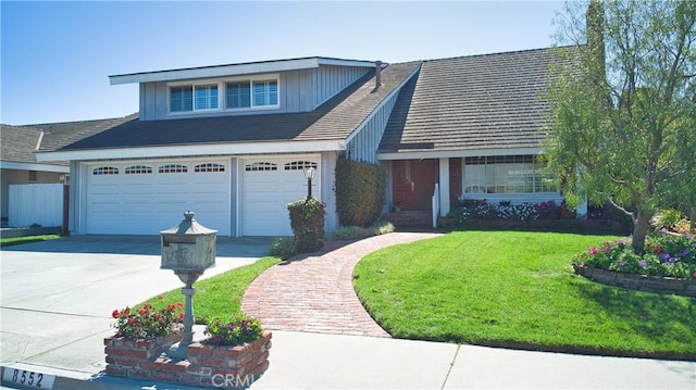 view of front facade with concrete driveway, an attached garage, and a front lawn