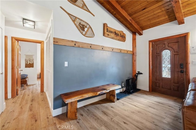 foyer featuring vaulted ceiling with beams, light wood-style floors, and wooden ceiling