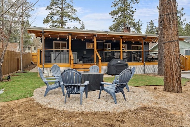 back of property featuring a yard, a chimney, fence, and a wooden deck