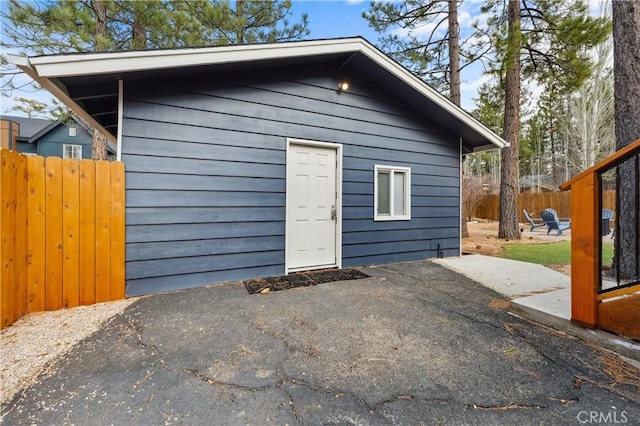 view of outbuilding featuring fence