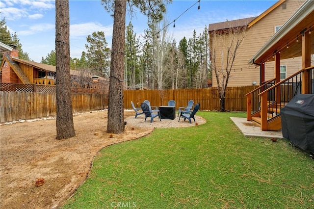 view of yard featuring a fenced backyard and a fire pit