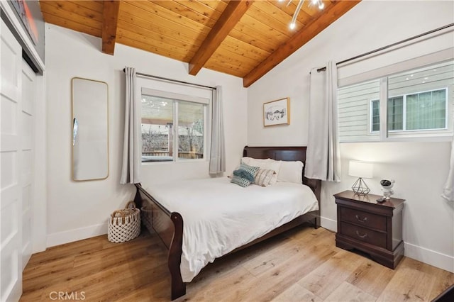 bedroom featuring lofted ceiling with beams, wood finished floors, wood ceiling, and baseboards