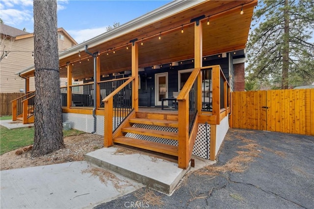 exterior space featuring covered porch and fence