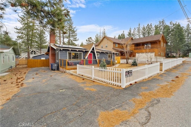 view of front of property with a fenced front yard and roof mounted solar panels