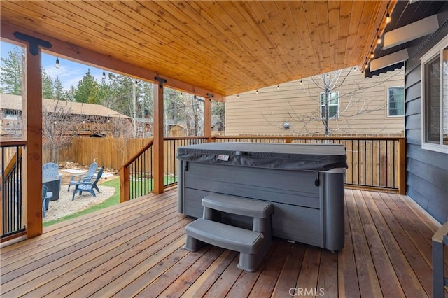 wooden terrace featuring fence and a hot tub